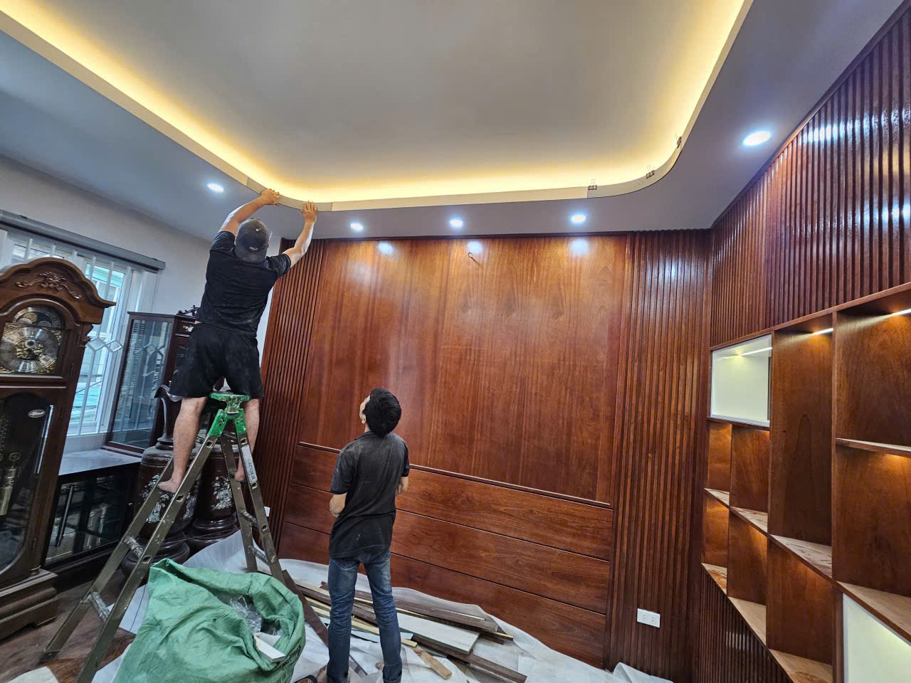 Thi công ốp tường gỗ tone trầm kết hợp hắt trần trong không gian phòng khách