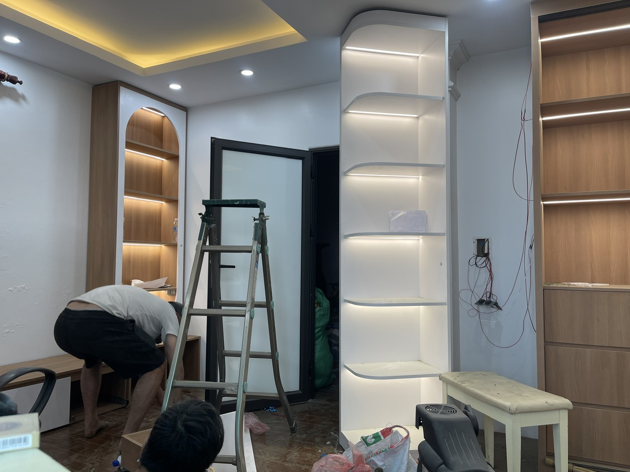 Không gian phòng ngủ với hệ kệ đèn LED và tủ đang trong giai đoạn lắp đặt
